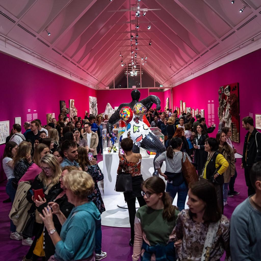 Besucher bestaunen bunte Skulpturen in Kunstausstellung